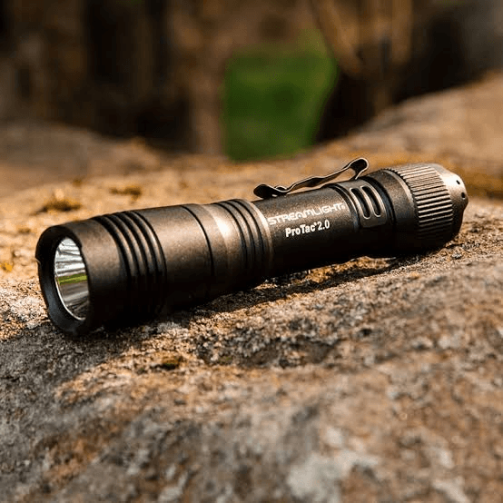 Outdoor flashlight resting on a rock to suggest field durability